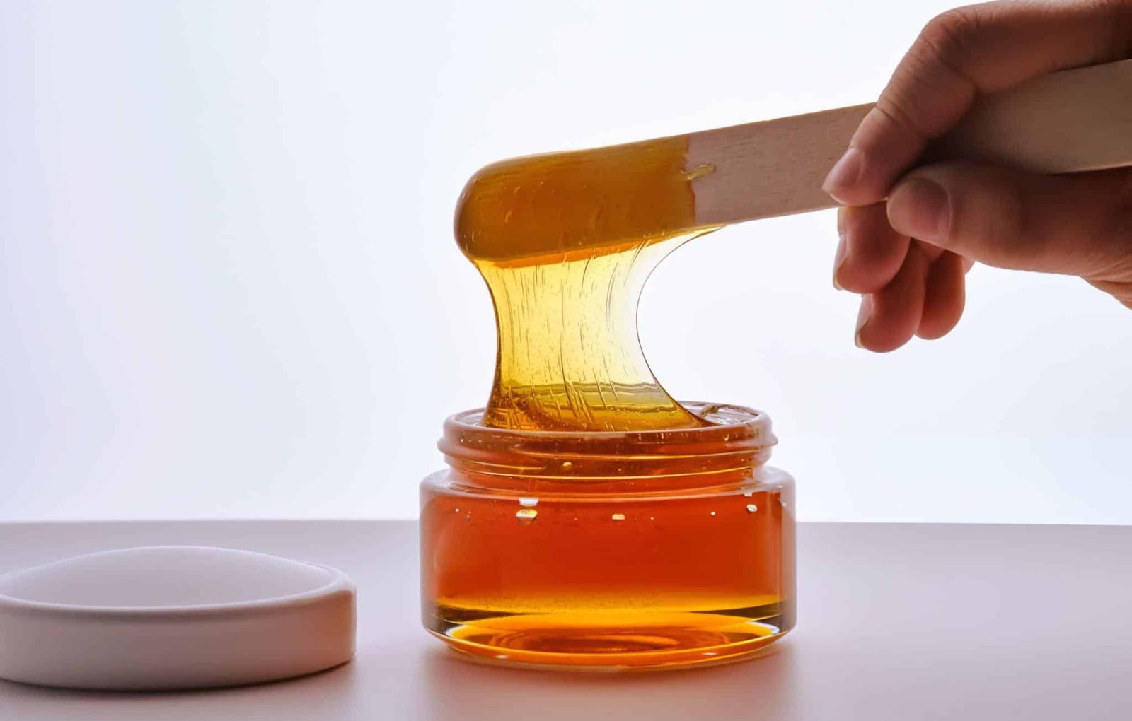 A bowl of sugar wax mixture with lemon and sugar