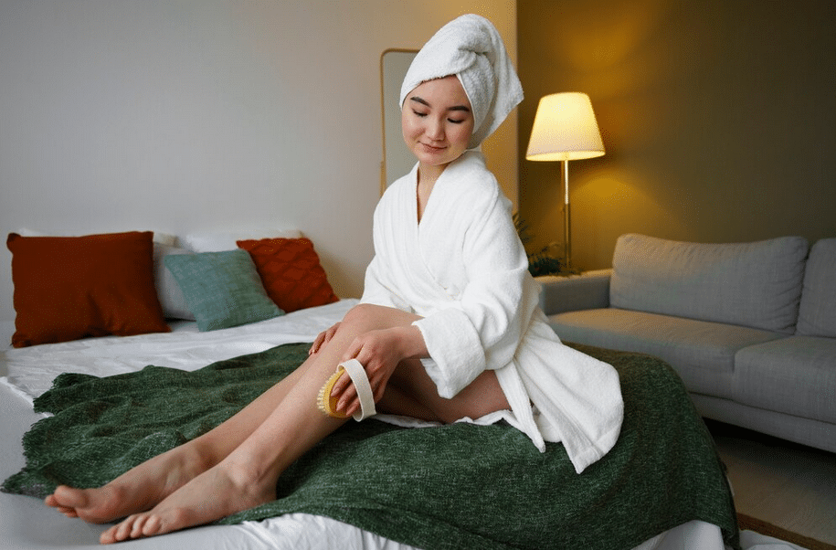 Woman using exfoliating scrub on leg to prevent ingrown hairs after Brazilian wax.