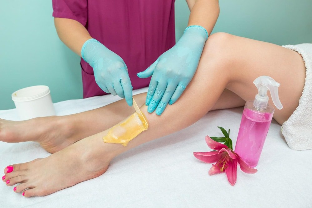Woman using a sugar paste for hair removal at home.